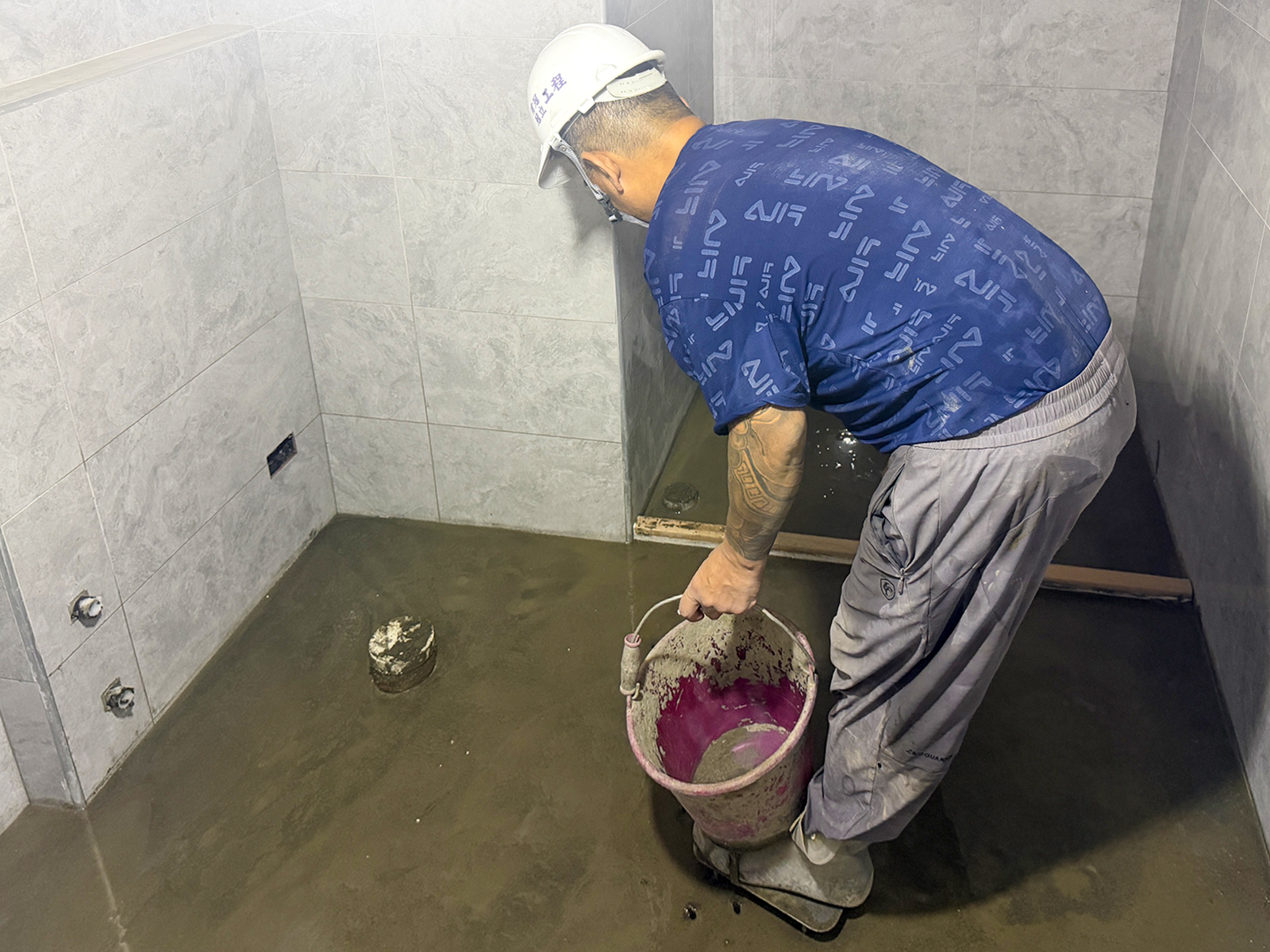 進行浴廁地磚鋪貼施作，以騷質砂漿整平並雙面抹益膠泥防澎拱