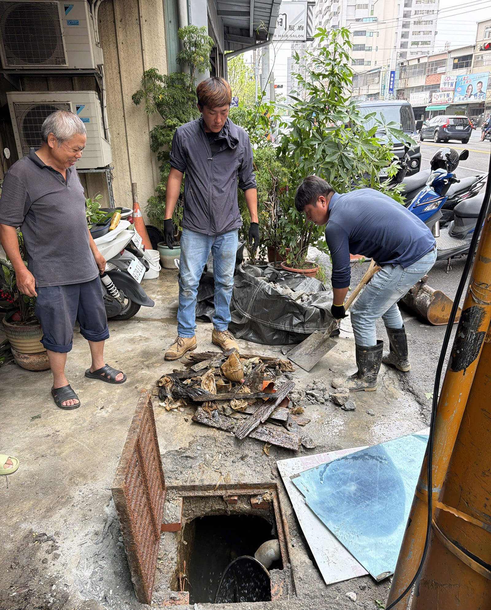 工地團隊人員積極清理工區外圍阻塞之水溝，改善住戶前積水問題
