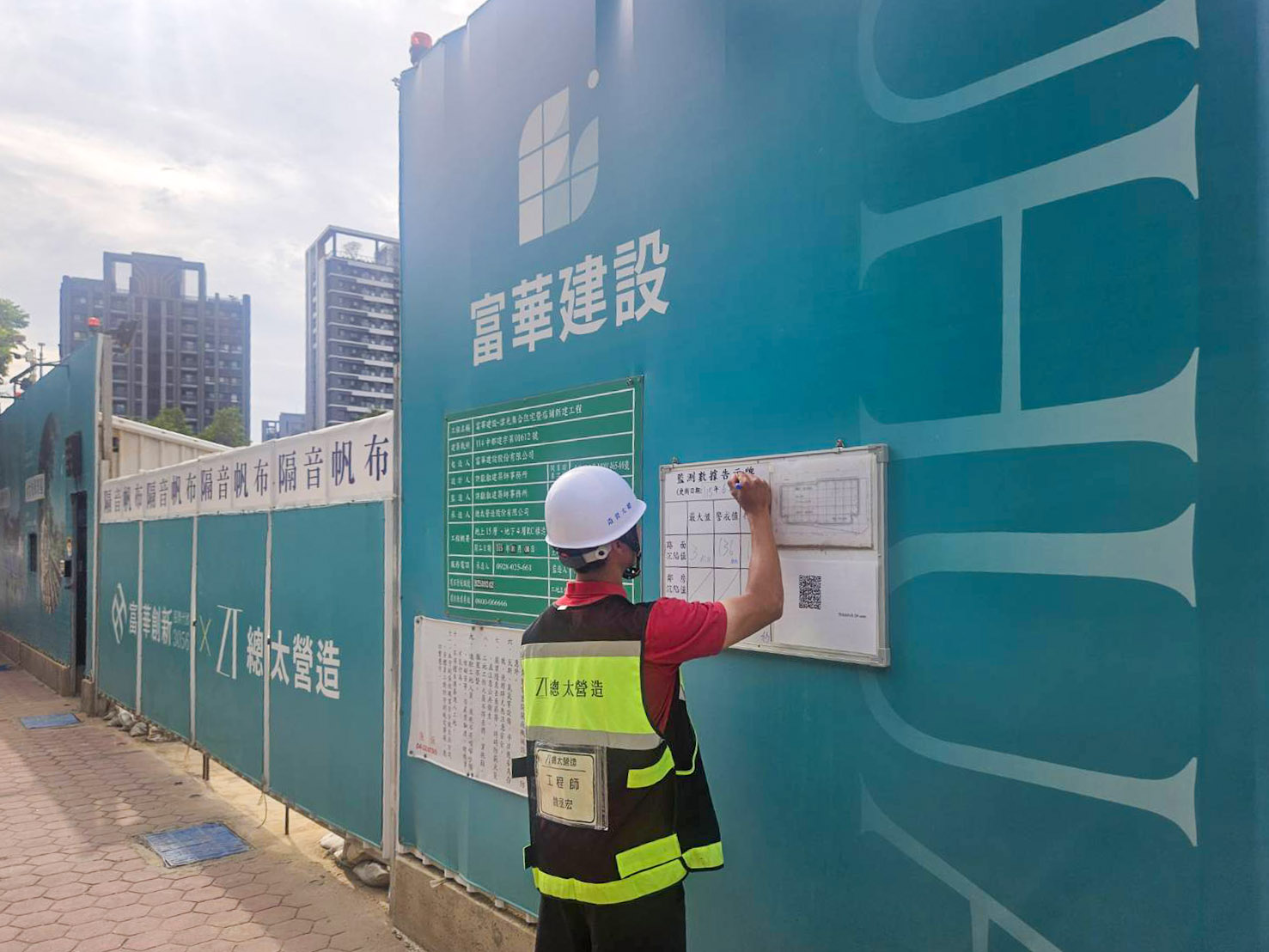 工程同仁在安全小白板更新並寫上最新沉陷測量值，向市民大眾公告