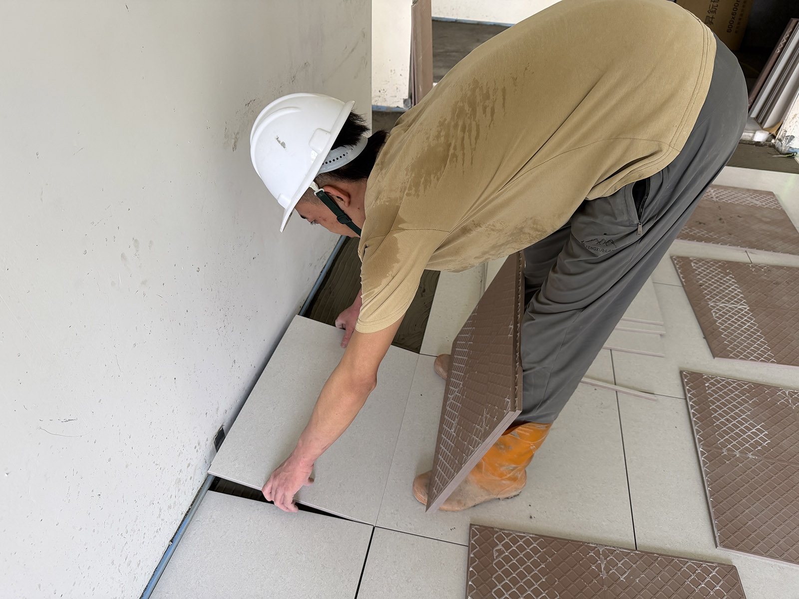 施工人員進行住宅陽台硬底磁磚鋪設，平整對齊