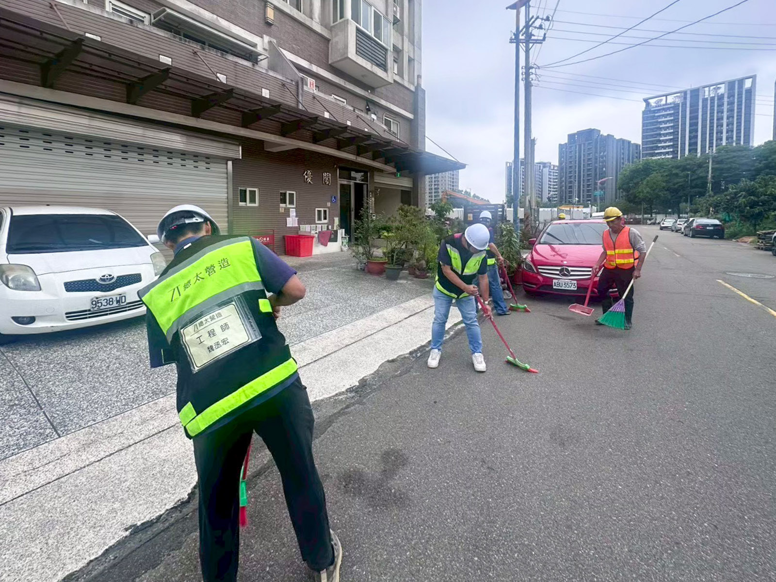 工務同仁拿著掃把主動清掃工區外圍馬路，確保街道整潔