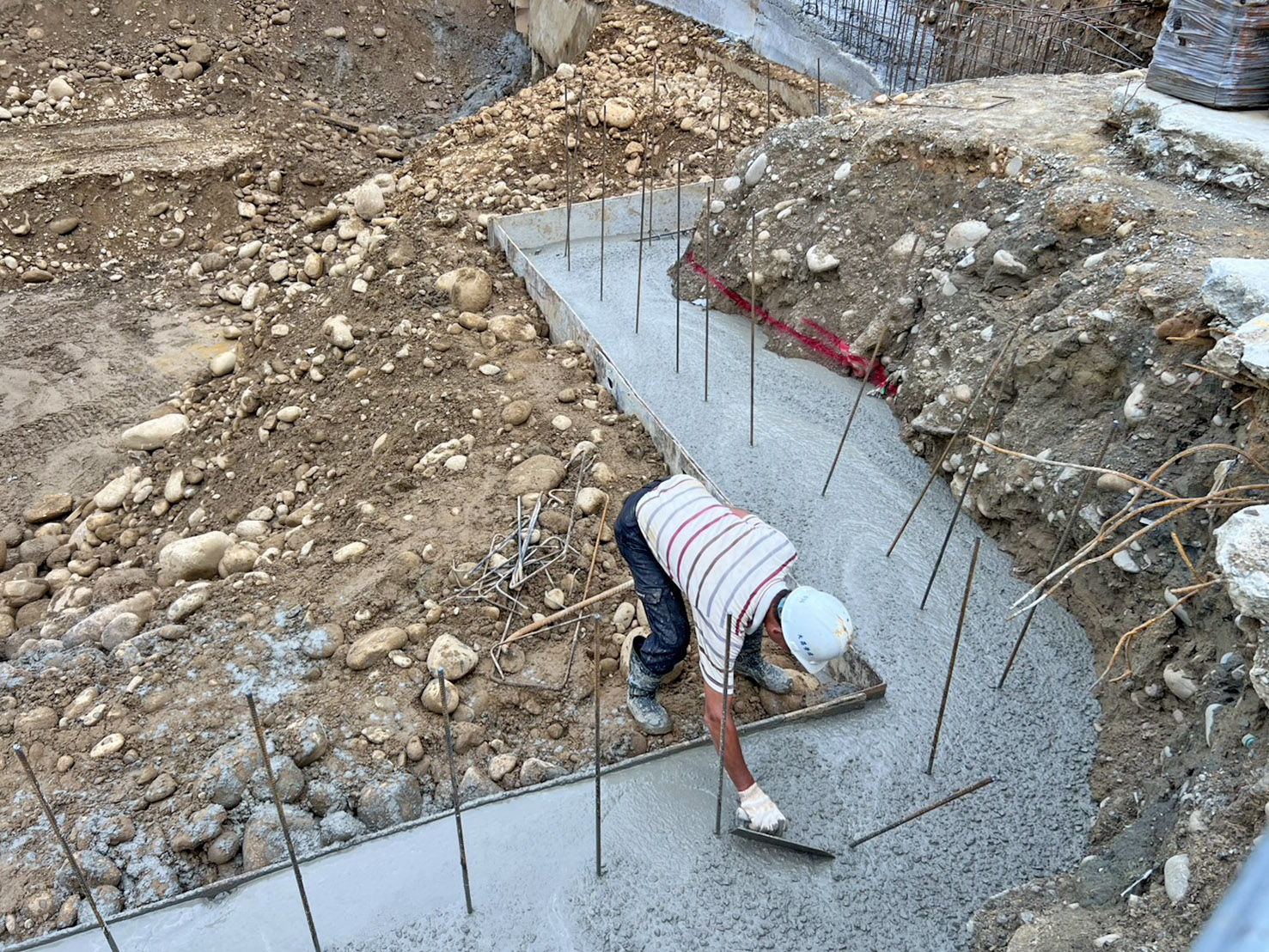 澐光工地排樁壓樑混凝土灌漿澆置，工班將表面抹平整