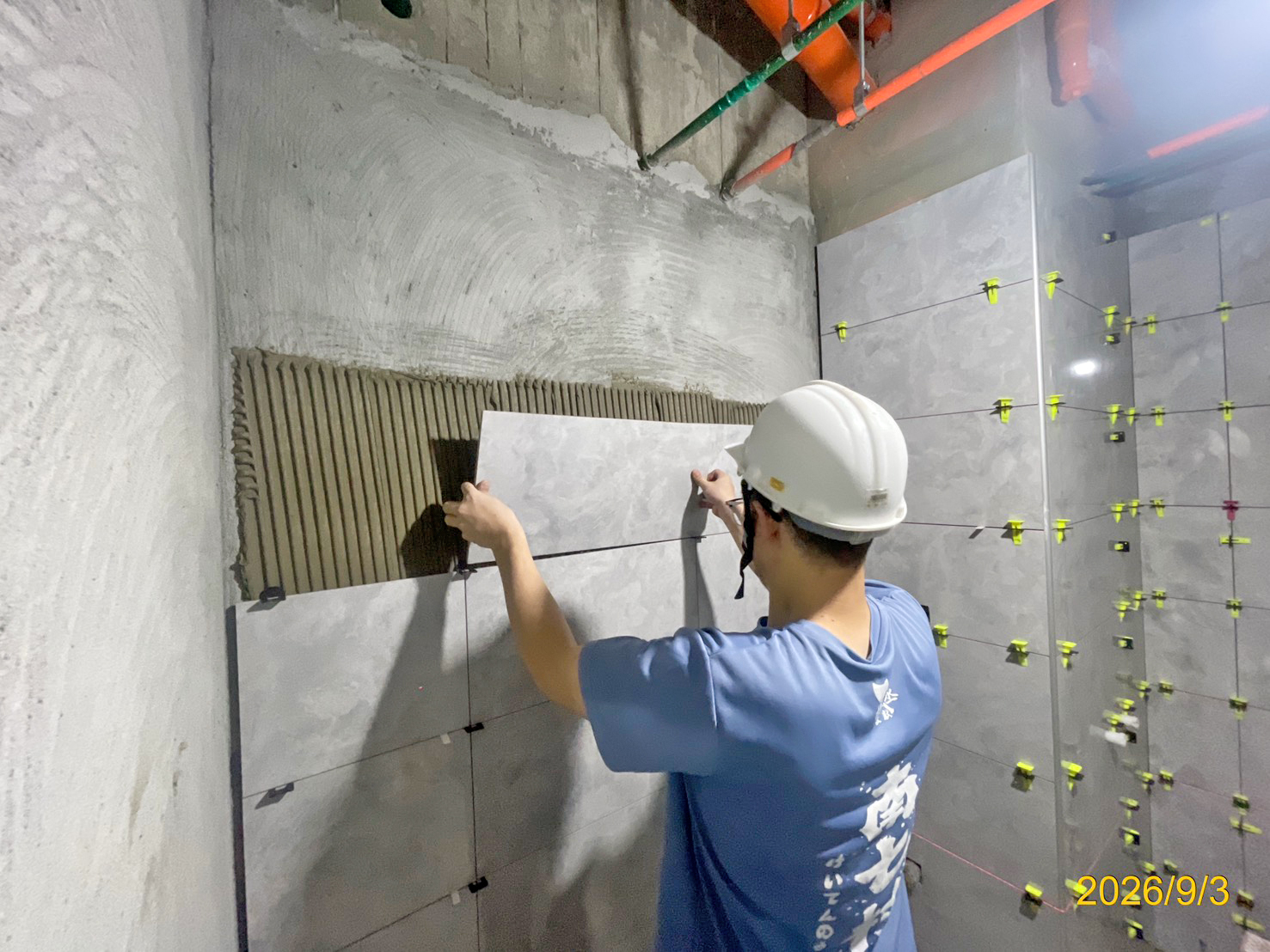 衛浴空間壁磚鋪貼作業，管控益膠泥均勻度並以十字夾定位縫隙